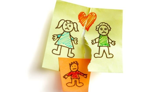 A torn piece of paper with a drawing of two parents on it, one on each piece of paper, sit on either side of another piece of paper with a drawing of a child on it, symbolizing divorce and custody.