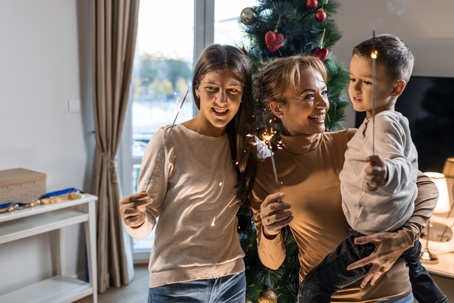 mother and children playing with sparklers during the holidays