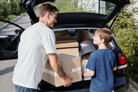 father and son loading up the car with moving boxes