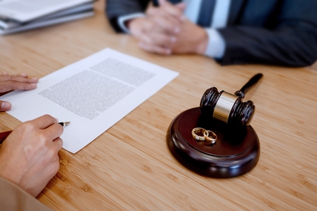 couple signing divorce papers in lawyer's office
