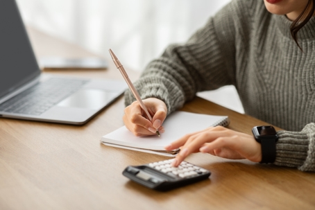 person budgeting using calculator