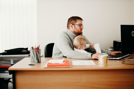 man working at computer with child