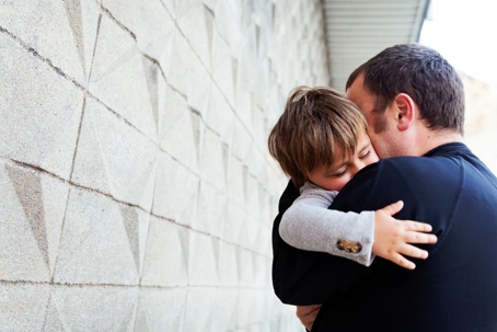 child being hugged by father